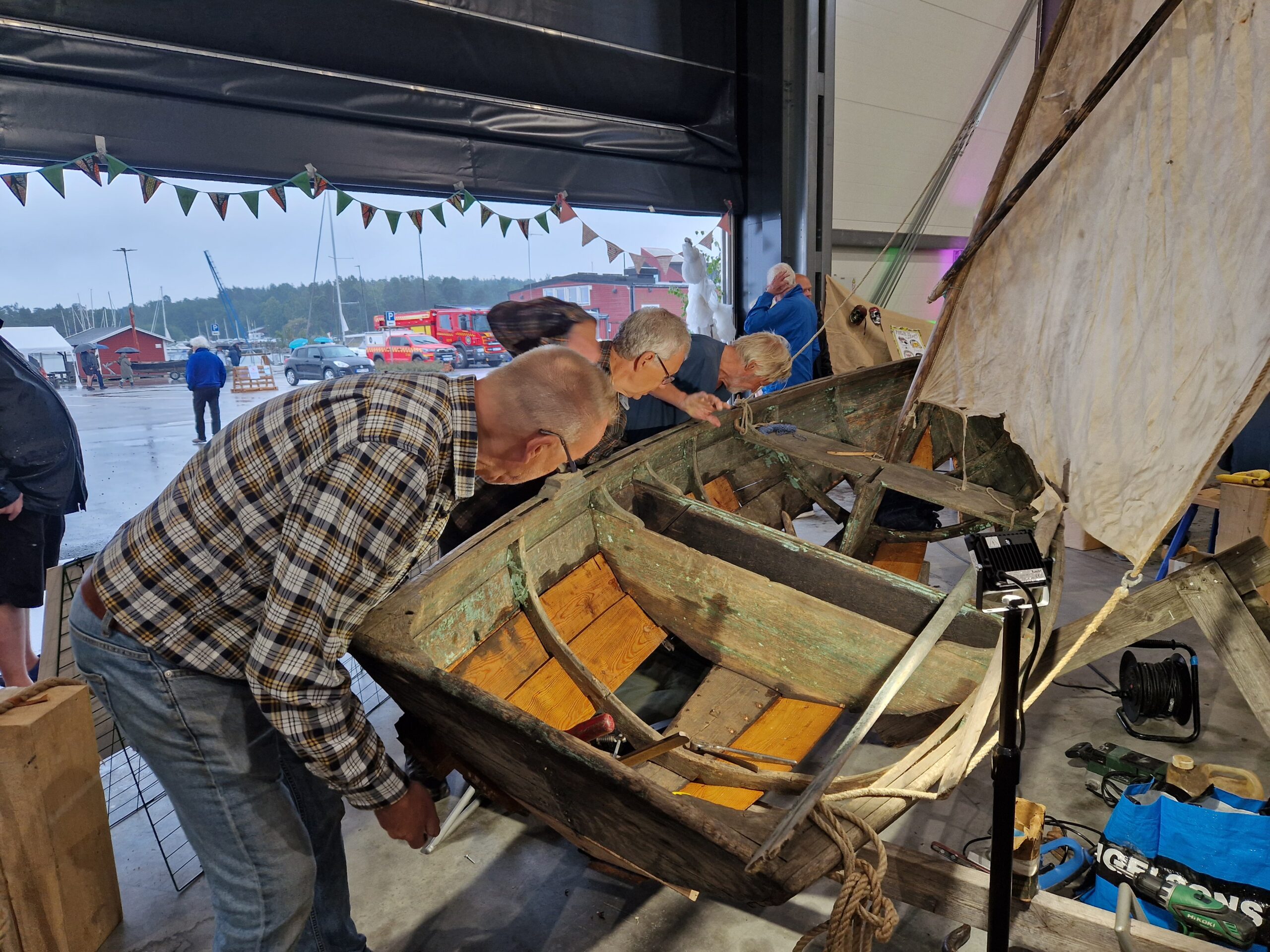 Besökare undersöker en traditionell träbåt under Femöredagen, en aktivitet inom Wooden Waves.